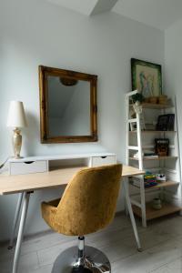 a desk with a chair and a mirror on a wall at Family Apartment - Centrum in Kudowa-Zdrój