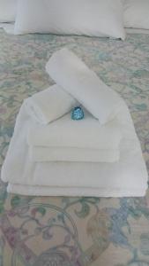 a bed with white towels and a blue bead on it at Giulio D'Este in Ferrara