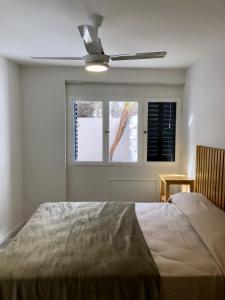 um quarto com uma cama e uma ventoinha de tecto em NvaCba Premium: a mts Pque de las Tejas, 1 dorm PB con patio, confort y diseño - ALOHA #4 em Córdoba
