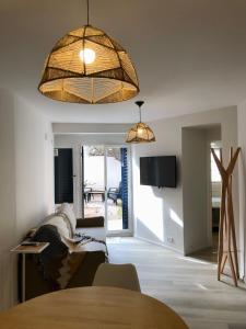 a living room with a table and a large light fixture at NvaCba Premium: a mts Pque de las Tejas, 1 dorm PB con patio, confort y diseño - ALOHA #4 in Cordoba