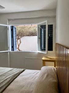 a bedroom with a bed and a large window at NvaCba Premium: a mts Pque de las Tejas, 1 dorm PB con patio, confort y diseño - ALOHA #4 in Cordoba