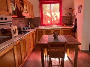 eine Küche mit einem Tisch mit Stühlen und einem Fenster in der Unterkunft A 5 MINUTI DA TRAPANI e FREE PARKING in Torre Nubia
