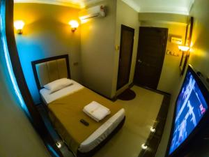 Habitación pequeña con cama y TV de pantalla plana. en Najmi Inn Hotel, 