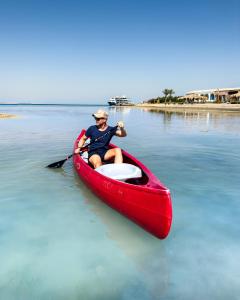 a man in a red canoe on the water at Gravity Hotel & Aqua Park Hurghada Families and Couples Only in Hurghada