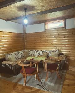 ein Wohnzimmer mit einem Sofa und einem Tisch in der Unterkunft Golden Wood House in Žabljak