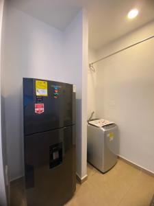 a black refrigerator and a trash can in a room at apartamento ubicado parte histórica de manizales in Manizales