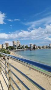uma vista para uma praia com uma cidade ao fundo em Coqueto loft con vistas inmejorables frente al mar em Alicante