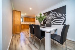 een eetkamer met een witte tafel en zwarte stoelen bij Blackacre Studio Verdun 