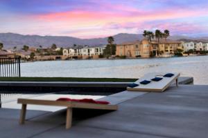 zwei Bänke auf einem Dock neben einem Wasserkörper in der Unterkunft Lakeside Serenity in Indio