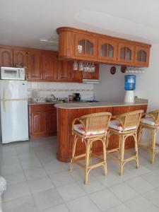 a kitchen with wooden cabinets and a white refrigerator at Tropical Optimal Tropicana Sur in Sosúa