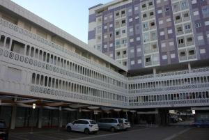 een groot gebouw met auto's geparkeerd voor het bij Monolocale con terrazza e cucina in Lignano Sabbiadoro