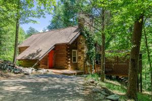 a log cabin in the woods with a red door at VERY private, real log cabin with hot tub! in Sevierville