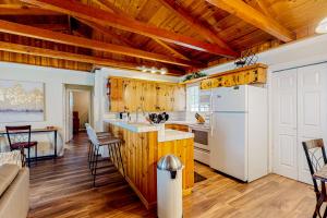 cocina con techos de madera y nevera blanca en Hounds of Aspen, en South Lake Tahoe