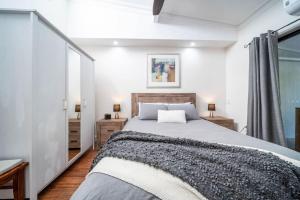 a bedroom with a large bed and a window at Plane Tree Cottage North Adelaide in Bowden