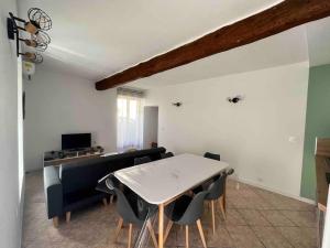 a living room with a white table and chairs at Maison coeur de village à Portiragnes in Portiragnes