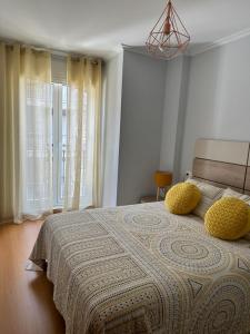 博伊羅的住宿－Apartamento Ría de Arousa，一间卧室配有一张带两个黄色枕头的床