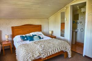 ein Schlafzimmer mit einem großen Bett mit blauen Kissen in der Unterkunft Hostal Triwe in Puerto Octay