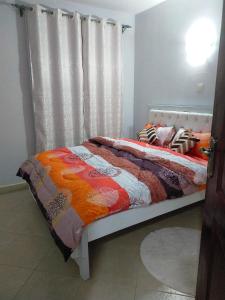 a bedroom with a bed with a quilt on it at One bedroom apartments tulivu in Thika