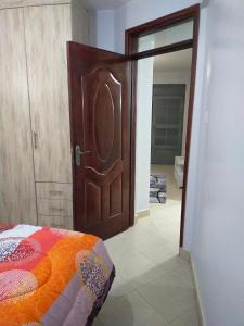 Un dormitorio con una gran puerta de madera y una cama en One bedroom apartments tulivu, en Thika