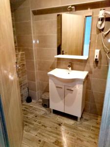 een badkamer met een witte wastafel en een spiegel bij Banin in Skradin