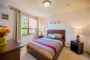 um quarto com uma cama, uma secretária e uma janela em Resort Style Living with Private Lawn and Patio em Kelowna