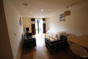 a bedroom with a bed and a couch and a table at Garden Court in West Drayton
