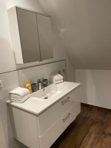 uma casa de banho branca com um lavatório e um espelho em Ferienwohnung Wintermoor em Schneverdingen