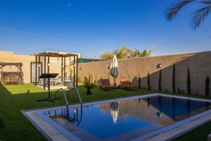 a backyard with a swimming pool and a swing at The little Cottage Chalet- B3 in Amman