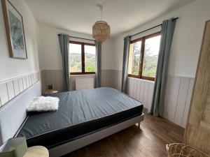 a bedroom with a bed and two windows at Le Plaisance, Beuil Les Launes in Beuil
