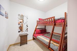 a childs bedroom with a bunk bed with red pillows at Resort Style Living with Private Lawn and Patio in Kelowna