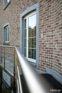 a window on a brick building with a metal railing at Villa&Loge in Lontzen