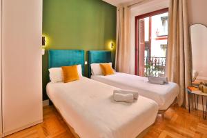 2 Betten in einem Zimmer mit grünen Wänden und einem Fenster in der Unterkunft #Madrid Centro. 3D. Gran Via. Callao.Puerta del Sol in Madrid