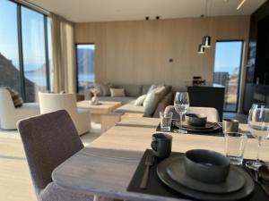 a dining room with a table and a living room at Luxury Lodge with jacuzzi and sauna in Kleppstad
