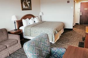 a hotel room with a bed and a couch at Hotel Topeka at City Center in Topeka