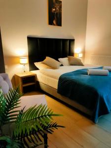 sypialnia z dużym łóżkiem i niebieskim kocem w obiekcie DoriSol w Solcu-Zdroju