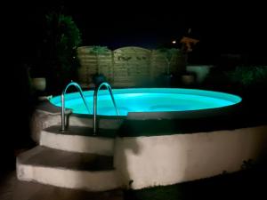 uma piscina à noite com luzes em Très jolie maison familiale, Piscine Cosy, havre de paix à 10 min des plages em Mauguio