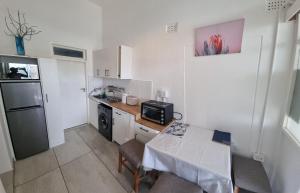 una pequeña cocina con mesa y microondas en SapphireA@54, en Windhoek