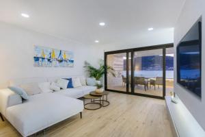a living room with a white couch and a large window at Seafront villa with roofpool, perfect getaway in Vinišće