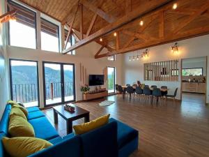 a living room with a blue couch and a dining room at Infinity Cabin in Râșca