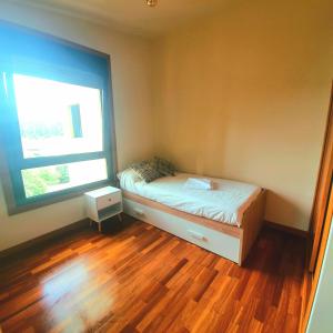 um pequeno quarto com uma cama e uma janela em Exclusivo atico en Salvaterra em Salvatierra de Miño