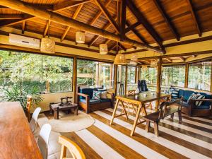 uma sala de estar com mesa e cadeiras em VELINN Hotel Santa Tereza em Ilhabela