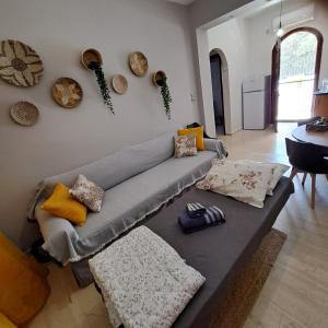 a living room with a gray couch with pillows at Ξενώνας Vasiliki in Vathí
