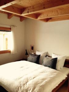 - une chambre avec un grand lit blanc et des oreillers dans l'établissement Chalet Sirius Dachwohnung, à Bettmeralp