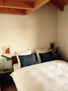 - une chambre avec un lit blanc et des oreillers bleus dans l'établissement Chalet Sirius Dachwohnung, à Bettmeralp