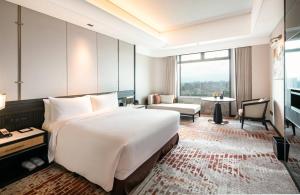 a hotel room with a large bed and a large window at InterContinental Foshan by IHG in Foshan