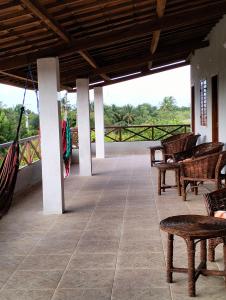 Pousada Villa Marini في إيتاريما: شرفة مع كراسي وأرجوحة على المنزل