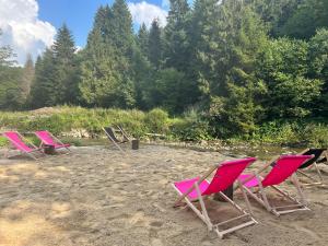 a group of lawn chairs sitting on a beach at Lawendowy Staw in Cisna