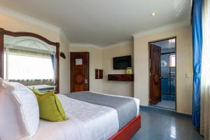 a bedroom with a large bed and a window at Lavid Hotel Palacio Real in Bogotá