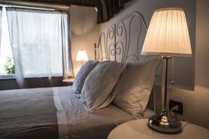 タオルミーナにあるLa Maison Jardin Apartmentのベッドルーム1室(ベッド1台、テーブルの上にランプ付)