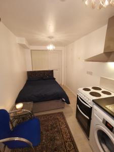 Argyll Studio Apartment - Luton Airport في لوتون: غرفة نوم صغيرة بها سرير وموقد